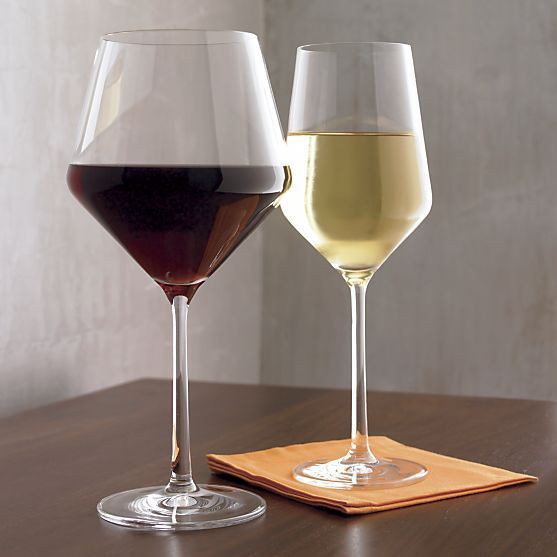 two glasses of wine sitting on top of a wooden table next to eachother