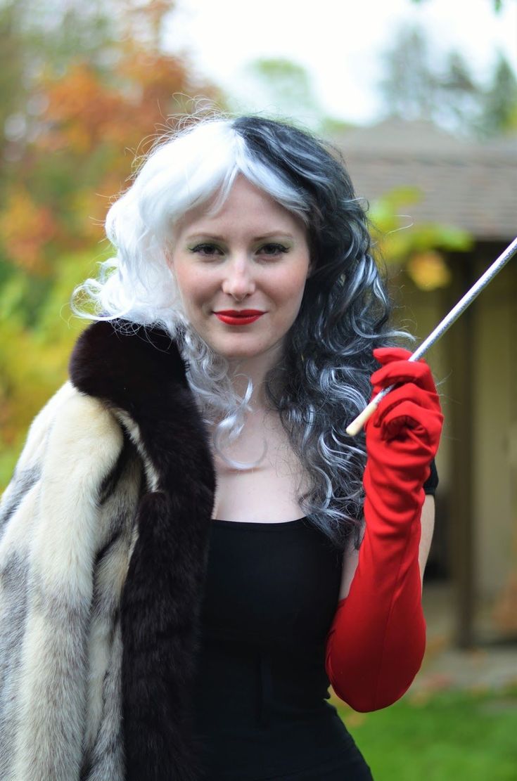 a woman dressed in black and white holding an umbrella