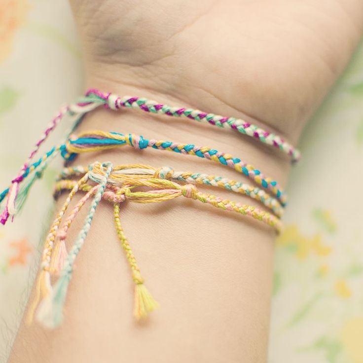 a woman's arm with three different colored bracelets on top of her wrist