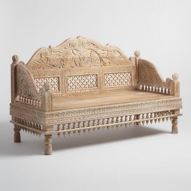 a wooden bench with intricate carvings on the back and sides, sitting in front of a white background