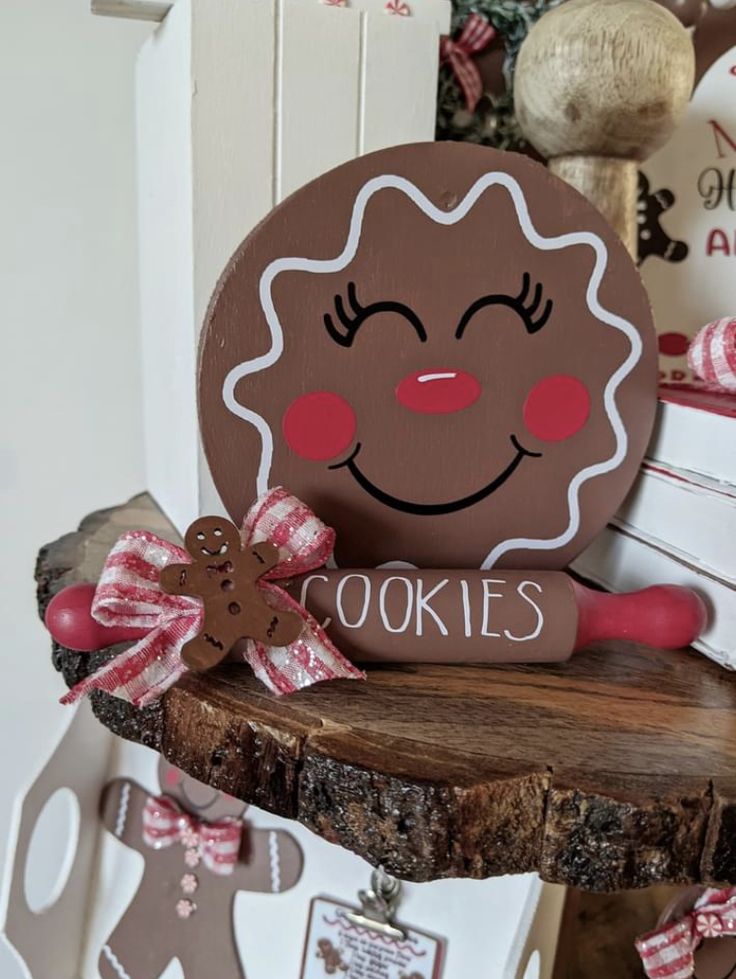 a wooden sign that says cookies with a ginger face on it sitting on top of a piece of wood