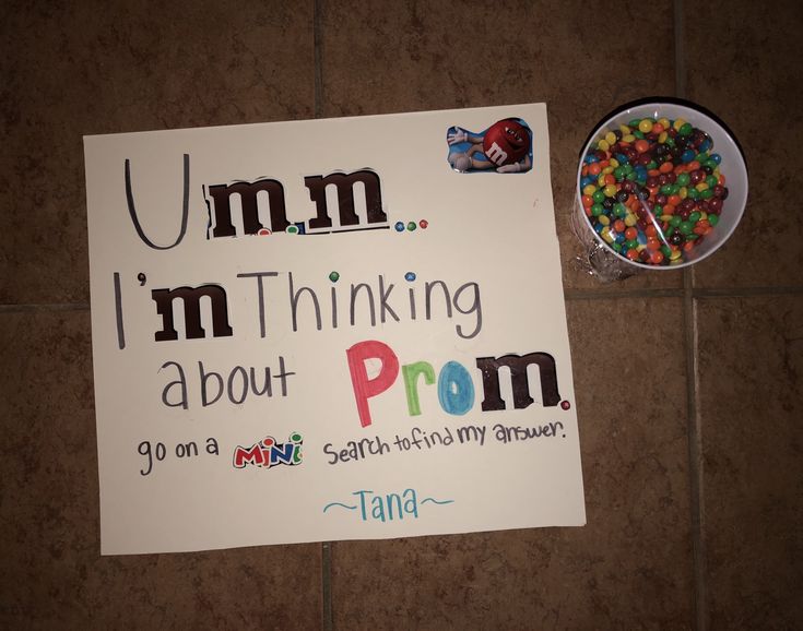 a sign that says i'm thinking about prom on it next to a bowl of candy