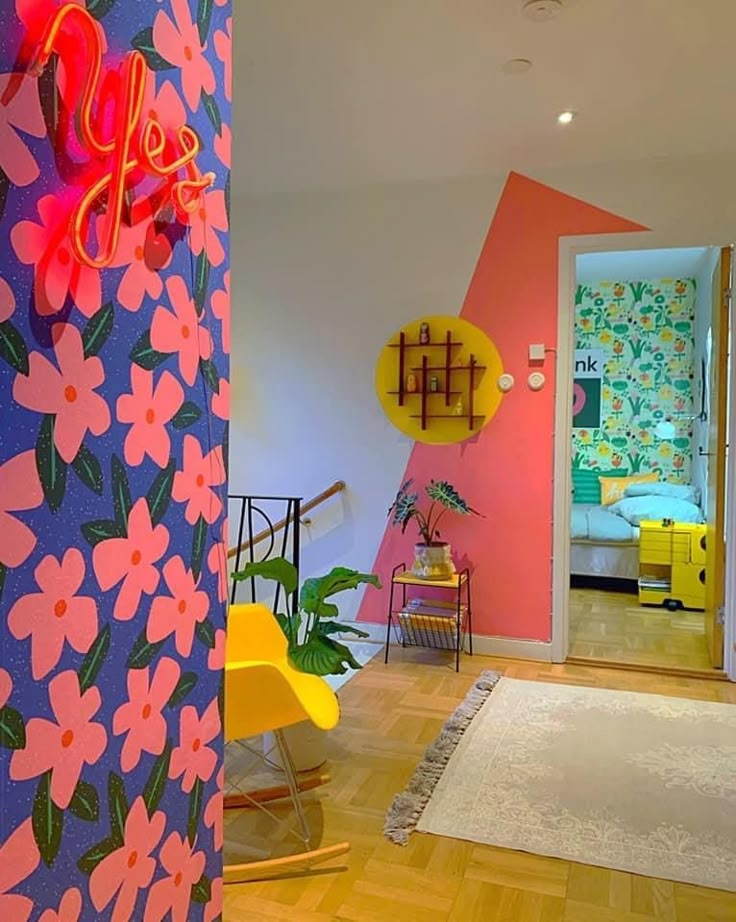 a brightly colored room with flowers painted on the walls and wooden floors, along with yellow chairs