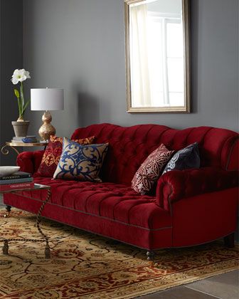 a living room with a red couch and christmas decorations on the wall above it,