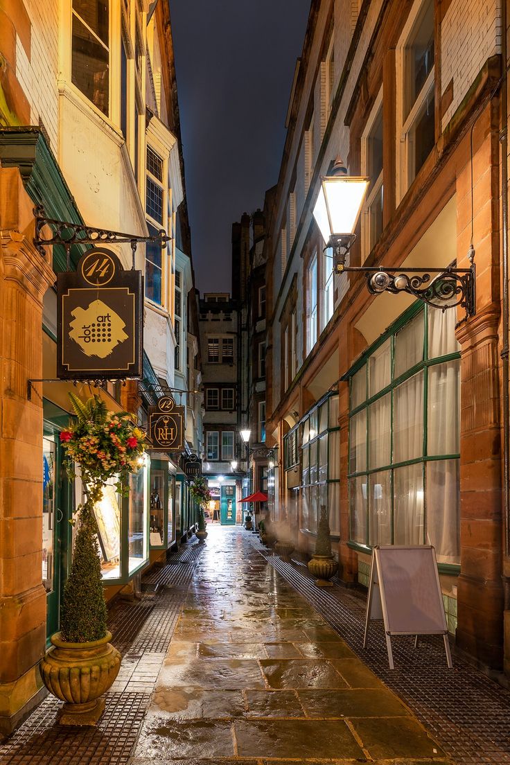 an empty city street at night with no one on the sidewalks or people walking down it