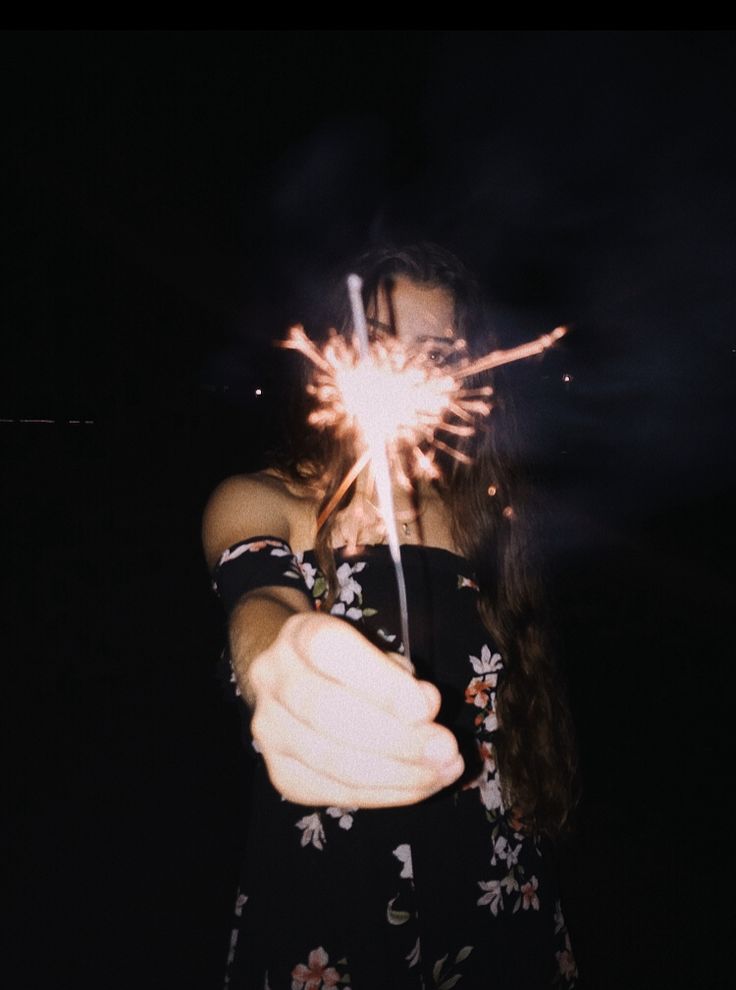 a woman holding a sparkler in her hand