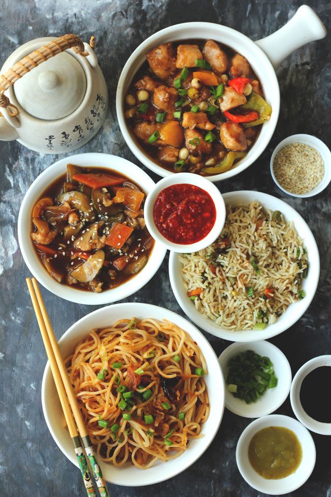 several bowls of food on a table with chopsticks and sauces next to them