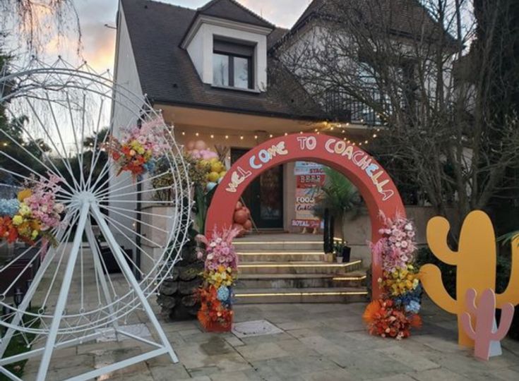 an entrance to a house decorated with fake flowers and cactus decorations in front of it