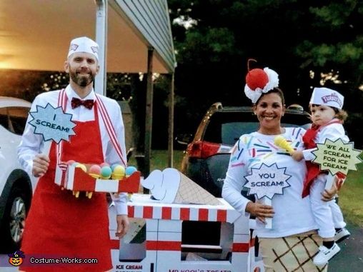 a man and woman are dressed up in costumes for an outdoor event while holding small children