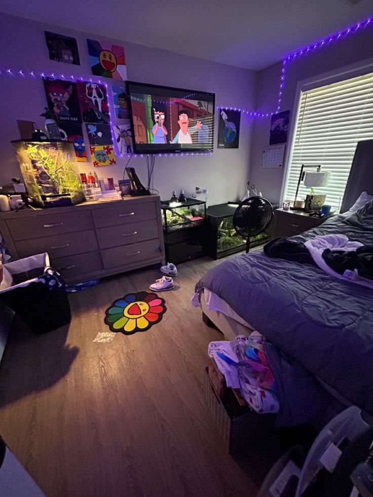 the bedroom is lit up with purple lights and pictures on the wall above the bed