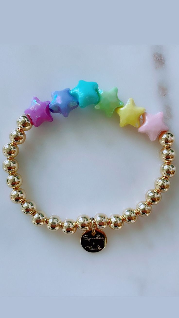 "This bracelet is handmade with love using iridescent stars and gold filled beads. **Please note the shipping time. This specific bracelet is a pre order, which means it will take anywhere between 1 - 3 weeks to arrive. To ensure a proper size, use a tape measure around your wrist. Place a dot where the tape measure meets. That is your wrist size! In our drop down menu, we have also included the average sizes for you. Please note we are not responsible if bracelet does not fit after providing th Rainbow Star-shaped Bracelet For Gift, Handmade Star-shaped Gold Bracelets, Handmade Gold Star Bracelets, Gold Bracelets With Star Charm And Round Beads, Gold Star Bracelets For Everyday, Teacher Bracelet, Pink Apple, Trendy Bracelets, Kids Bracelets