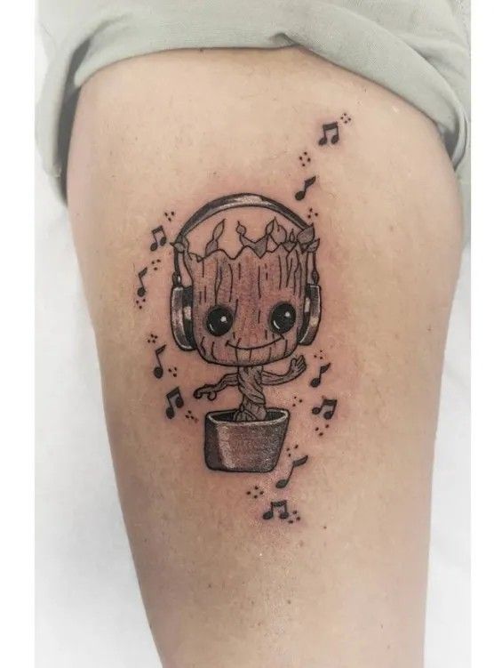 a person with headphones and music notes on their thighs is shown in this tattoo