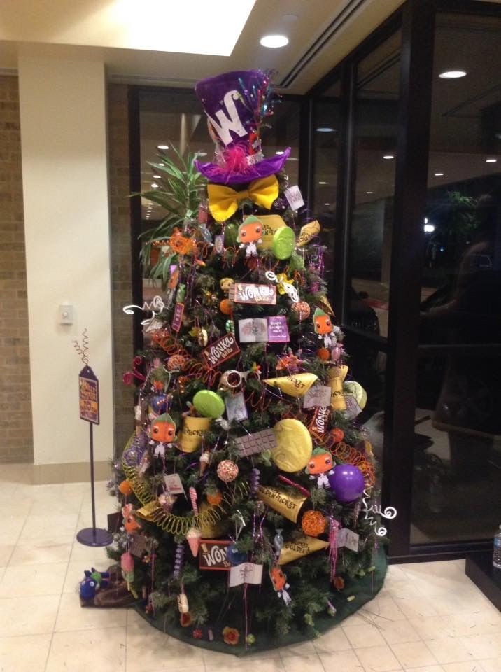 a decorated christmas tree with purple and yellow decorations in an office building lobby or waiting area