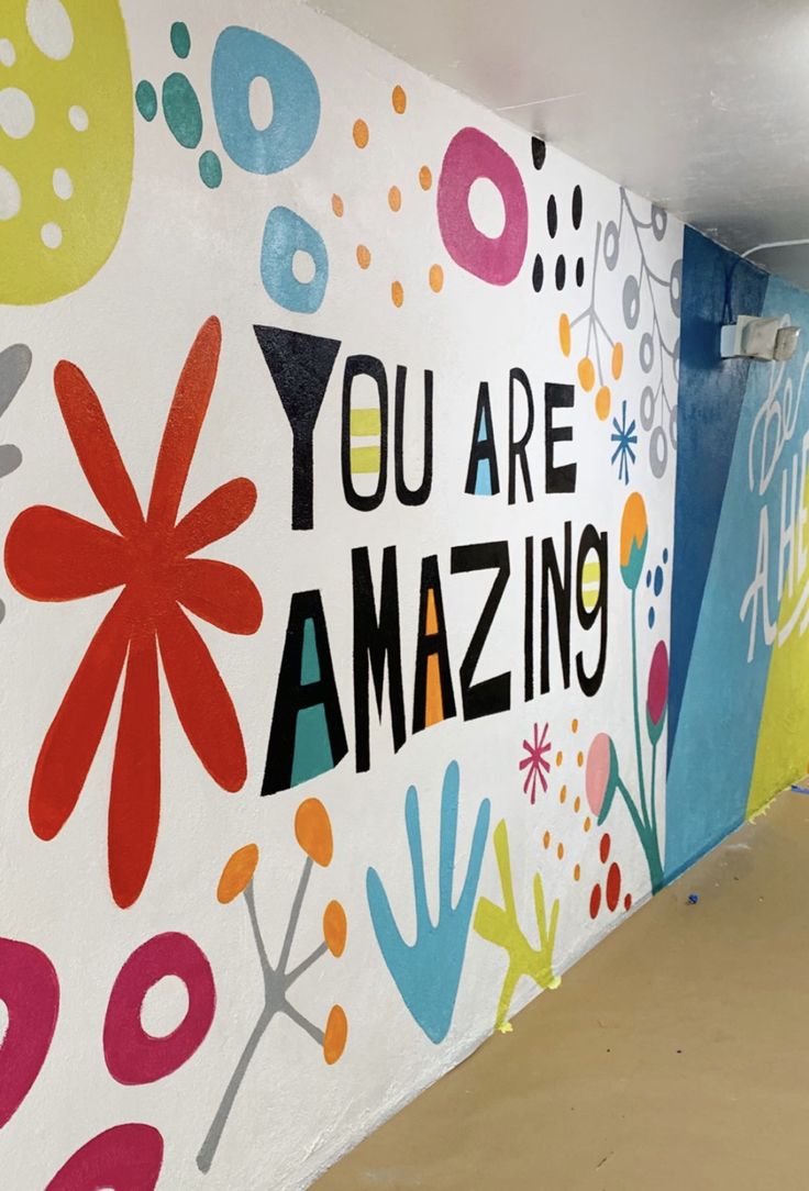 a wall painted with colorful flowers and words that say you are amazing on the side