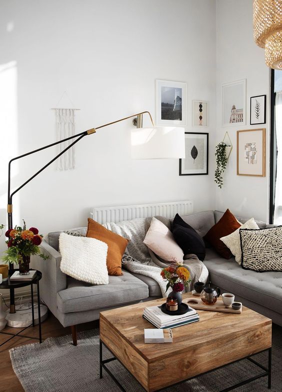 a living room filled with furniture and pictures on the wall next to a coffee table