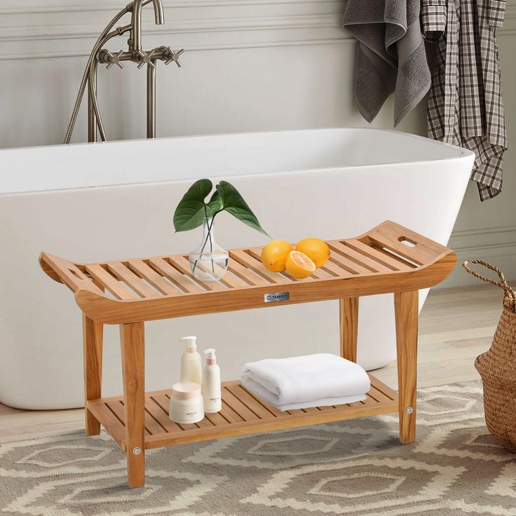 a bathroom with a bathtub, towel rack and oranges on the shelf next to it