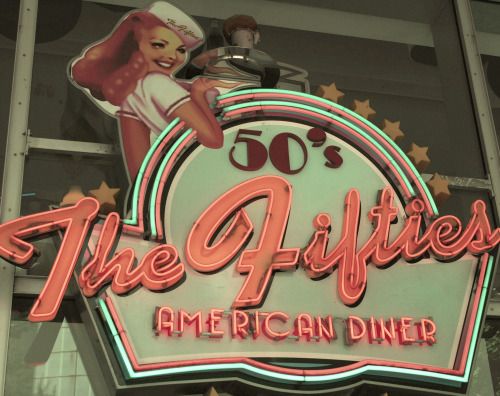 the sign for the fifties american diner is lit up