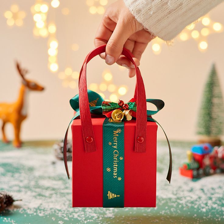 a person holding a red bag with christmas decorations on it