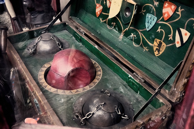 an old wooden box filled with lots of metal items on top of a green table