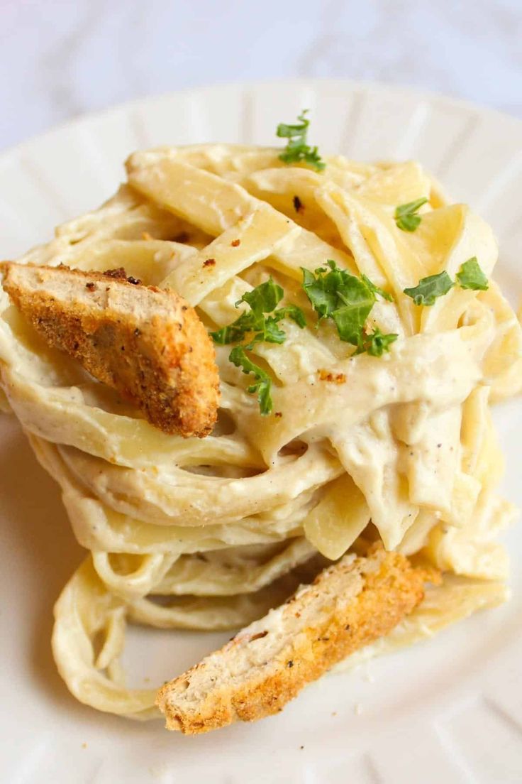 a white plate topped with pasta covered in sauce