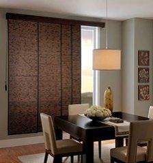 a dining room table and chairs in front of a sliding glass door with brown blinds