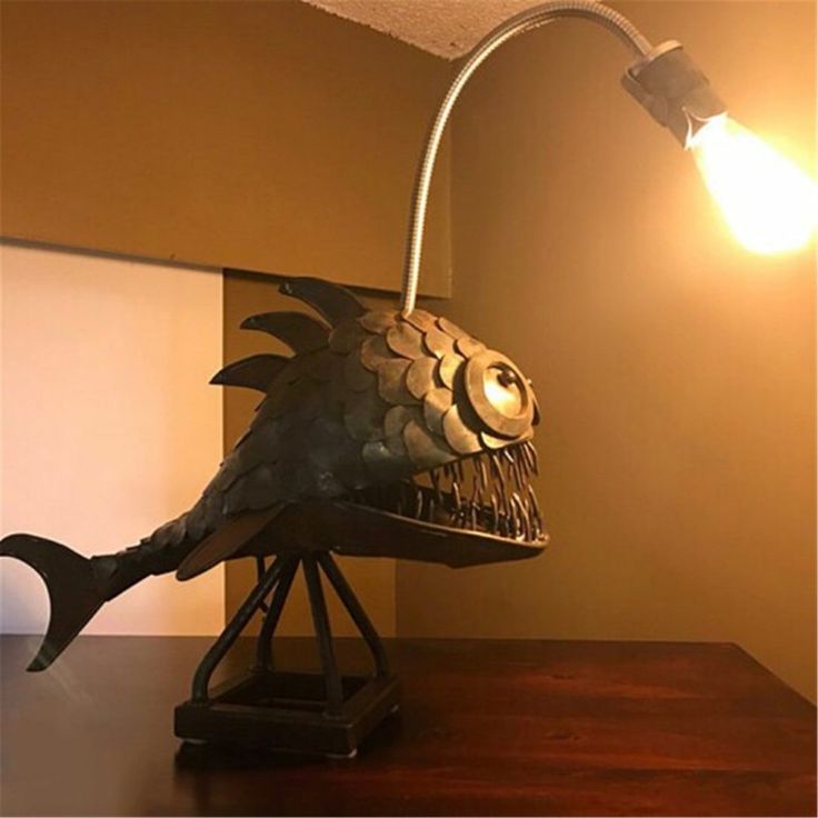 a lamp that is sitting on top of a table next to a cell phone and keyboard