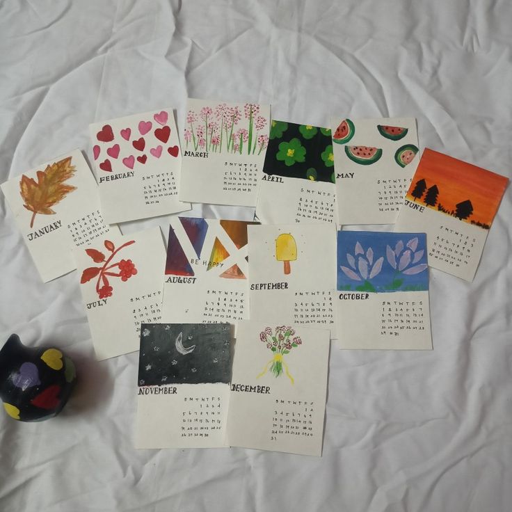 several calendars are laid out on a sheet of white paper with different designs and colors