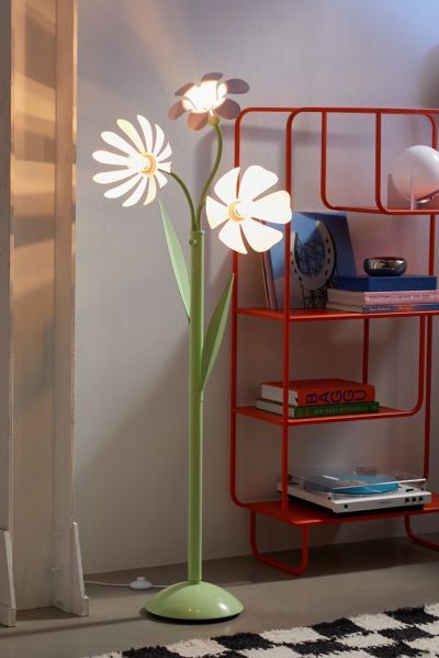 a lamp that is on top of a shelf next to a flower pot and books