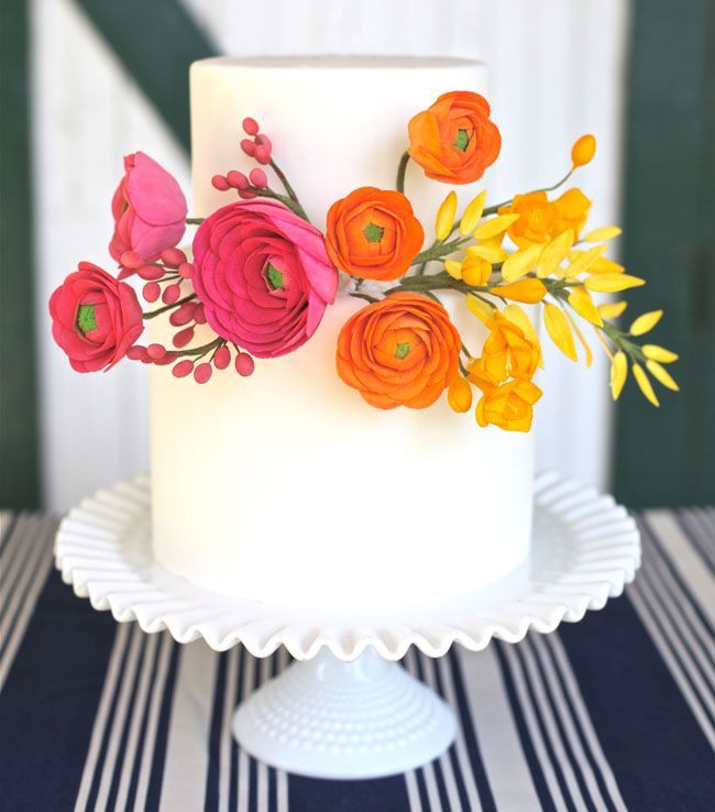 a white cake with flowers on it sitting on a table