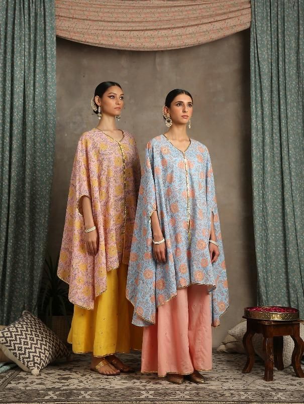 Set of 2 consists of cape and palazzo. Bouquet of floral yellows hand-printed on a pastel peach base. A quintessential summer cape/kaftan set perfect for the upcoming festivities. Comes with dainty gota highlights and handmade button detailing. Combined with kali palazzo in yellow with handwork zari and gota detailing. Colour - Peach Material - Cotton and Kota Doria Occasion - Festive Wear Fit - Relaxed and Flowy Pattern - Printed Care - Dry Clean only Estimated Delivery 15-20 days Heer- These a Traditional Peach Dupatta For Spring, Traditional Spring Matching Set Kurta, Cotton Palazzo Set With Traditional Drape For Spring, Festive Peach Sets For Spring, Pink Bohemian Palazzo Set For Spring, Traditional Peach Festive Sets, Peach Cotton Sets For Summer, Bohemian Pink Palazzo Set For Spring, Traditional Summer Sets With Cape Sleeves