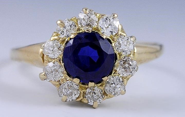 Presented is a vintage, 14 karat yellow gold, sapphire and diamond ring made in America during the turn of the 20th century. This piece was made between 1890 and 1910. The decorative top of the ring is done in a bullseye form with a wonderful, faceted sapphire surrounded by 10 old mine cut diamonds. The sapphire is a real (mined from the ground) sapphire. The stones are all well set with secure prongs. The diamonds are approximately 6 points each (60 points or over a half carat of total diamond Vintage Gold Sapphire Jewelry, Vintage Sapphire Ring With Halo Setting For Formal Occasions, Vintage Round Sapphire Ring, Vintage Gold Sapphire Ring, Vintage Sapphire Ring With Prong Setting, Vintage Sapphire Ring In Yellow Gold With Prong Setting, Vintage 14k Stamped Sapphire Ring For Formal Occasions, Vintage Gold Sapphire Ring With Round Cut, Vintage Yellow Gold Sapphire Ring