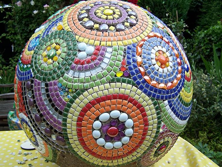 a colorful vase sitting on top of a table covered in lots of different colored tiles