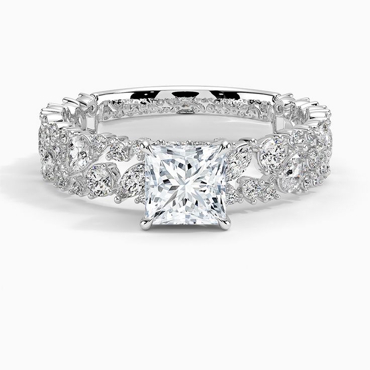 a princess cut diamond engagement ring with pave set diamonds on the band and side stones