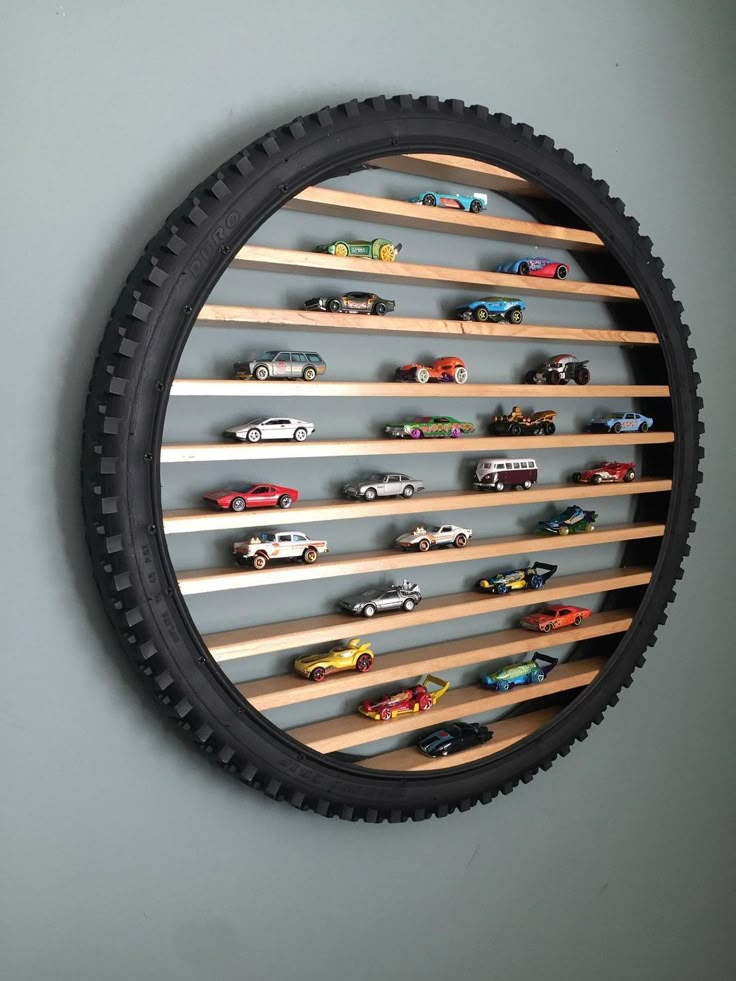 a wall mounted toy car display in the shape of a tire