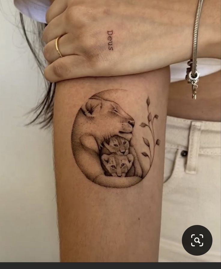 a woman's arm with a tattoo on it that has an image of a mother bear and her cubs