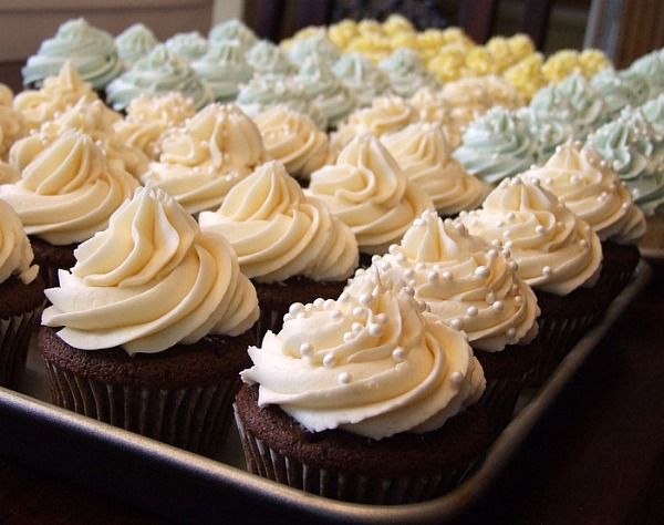 there are many cupcakes with white frosting on them