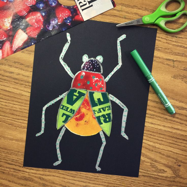 a drawing of a bug on a piece of paper next to markers and pencils