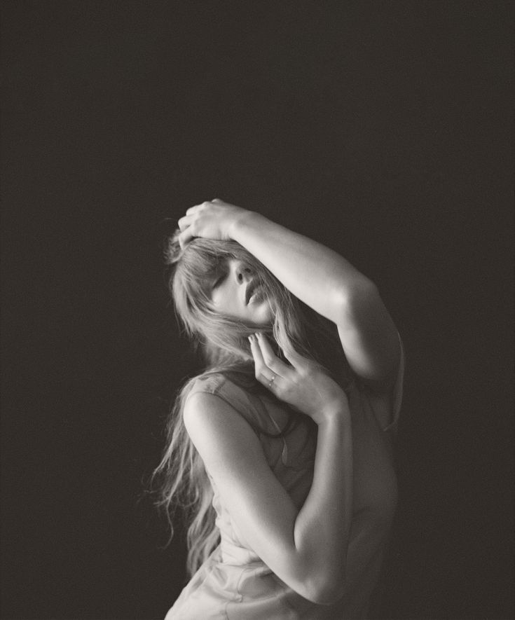 a black and white photo of a woman with her hands on her head