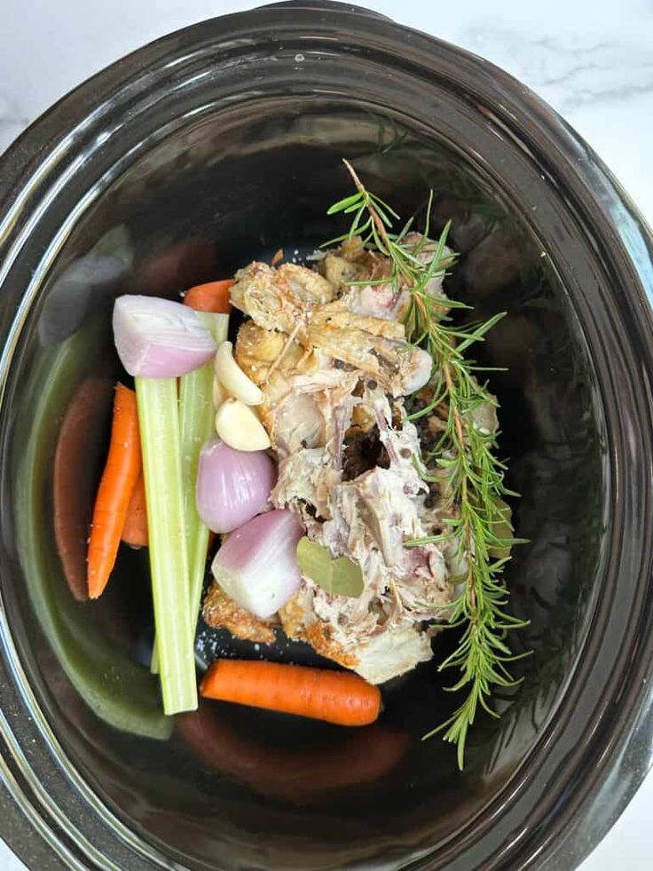 a bowl filled with meat and vegetables on top of a table