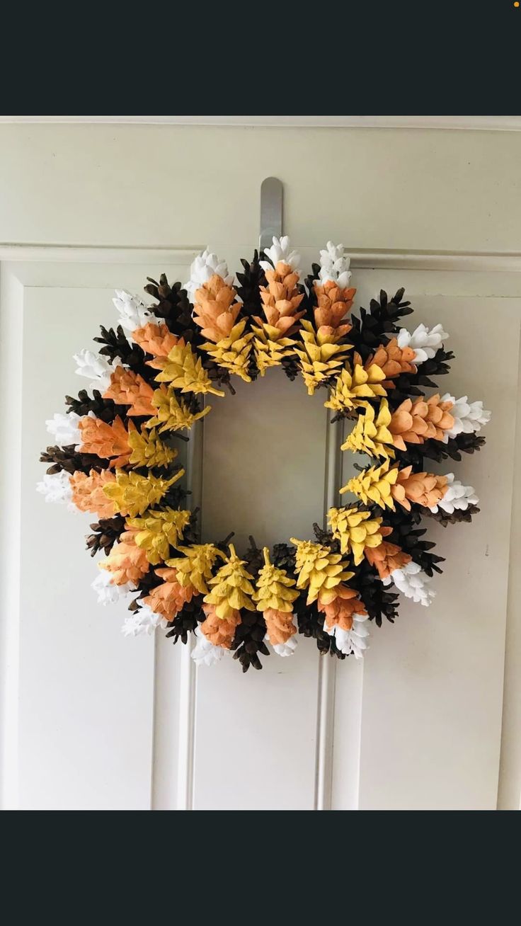 a wreath made out of pine cones and leaves on the front door with text reading crafting with the shabby tree simple, but happy with how it came out