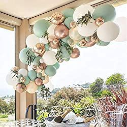 a dining room table and chairs with balloons hanging from it's ceiling in front of an open window