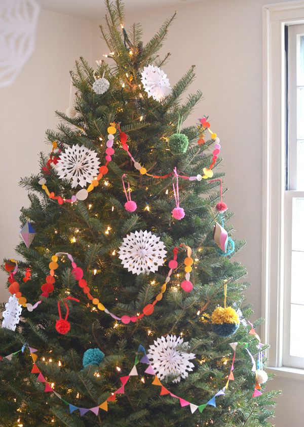 a decorated christmas tree in the corner of a room with lights and decorations on it