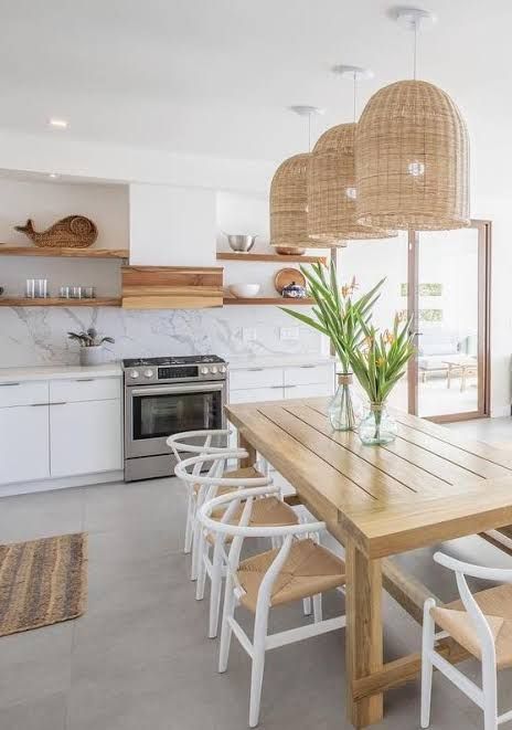 a wooden table sitting in the middle of a kitchen next to a stove top oven