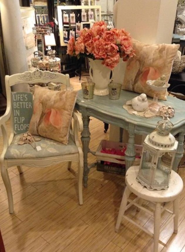 two chairs and a table with flowers in vases on top of them, sitting next to each other