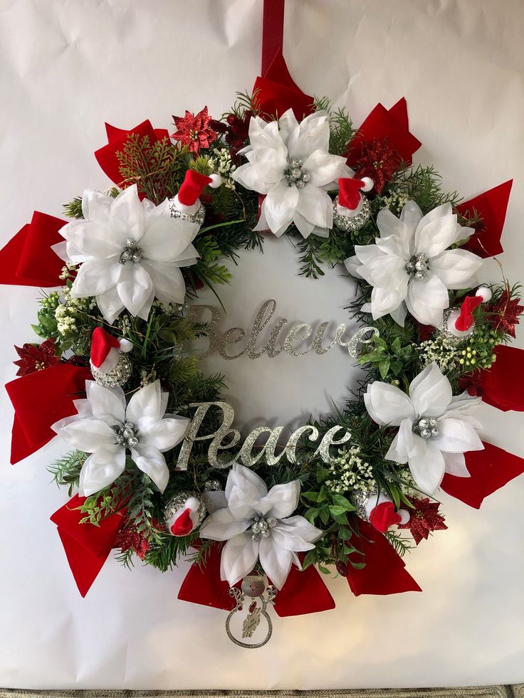 a christmas wreath with white and red flowers