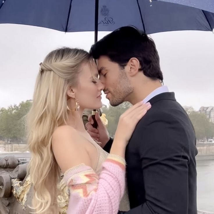 a man and woman kissing under an umbrella