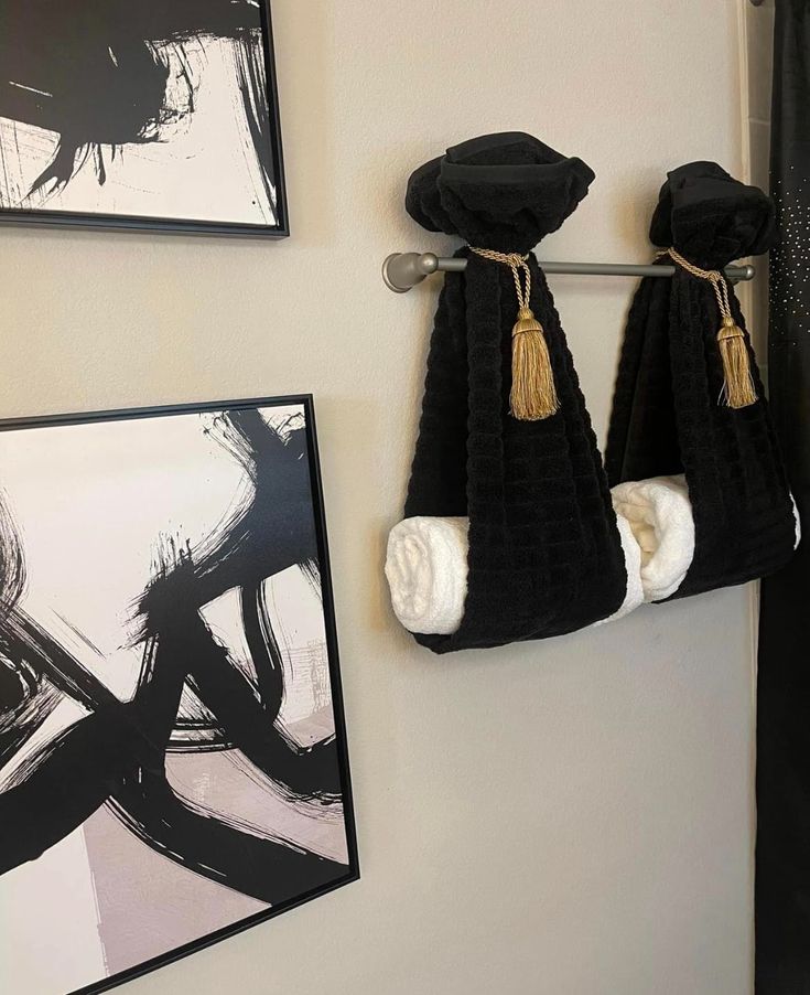 two black towels are hanging on the wall