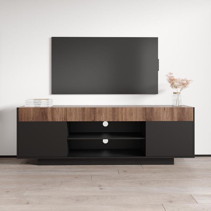 an entertainment center with a flat screen tv mounted on the wall and two vases in front of it