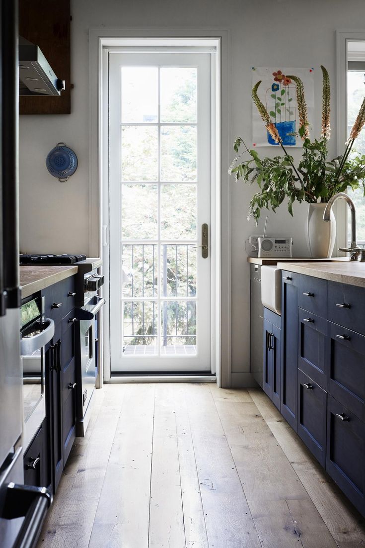 a kitchen with wooden floors and blue cabinets