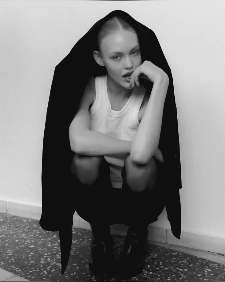 a black and white photo of a woman sitting on the ground